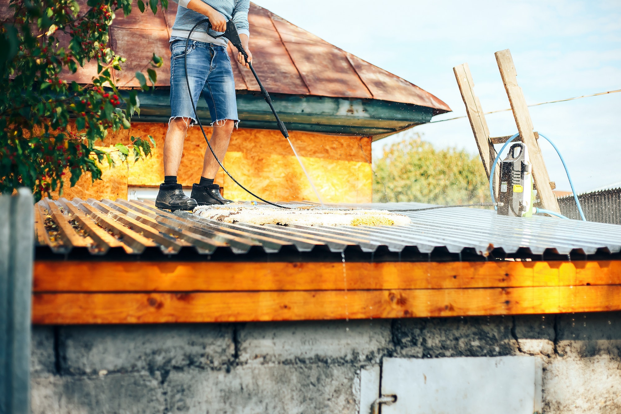 man wach clean carpet outdoor on roof with water