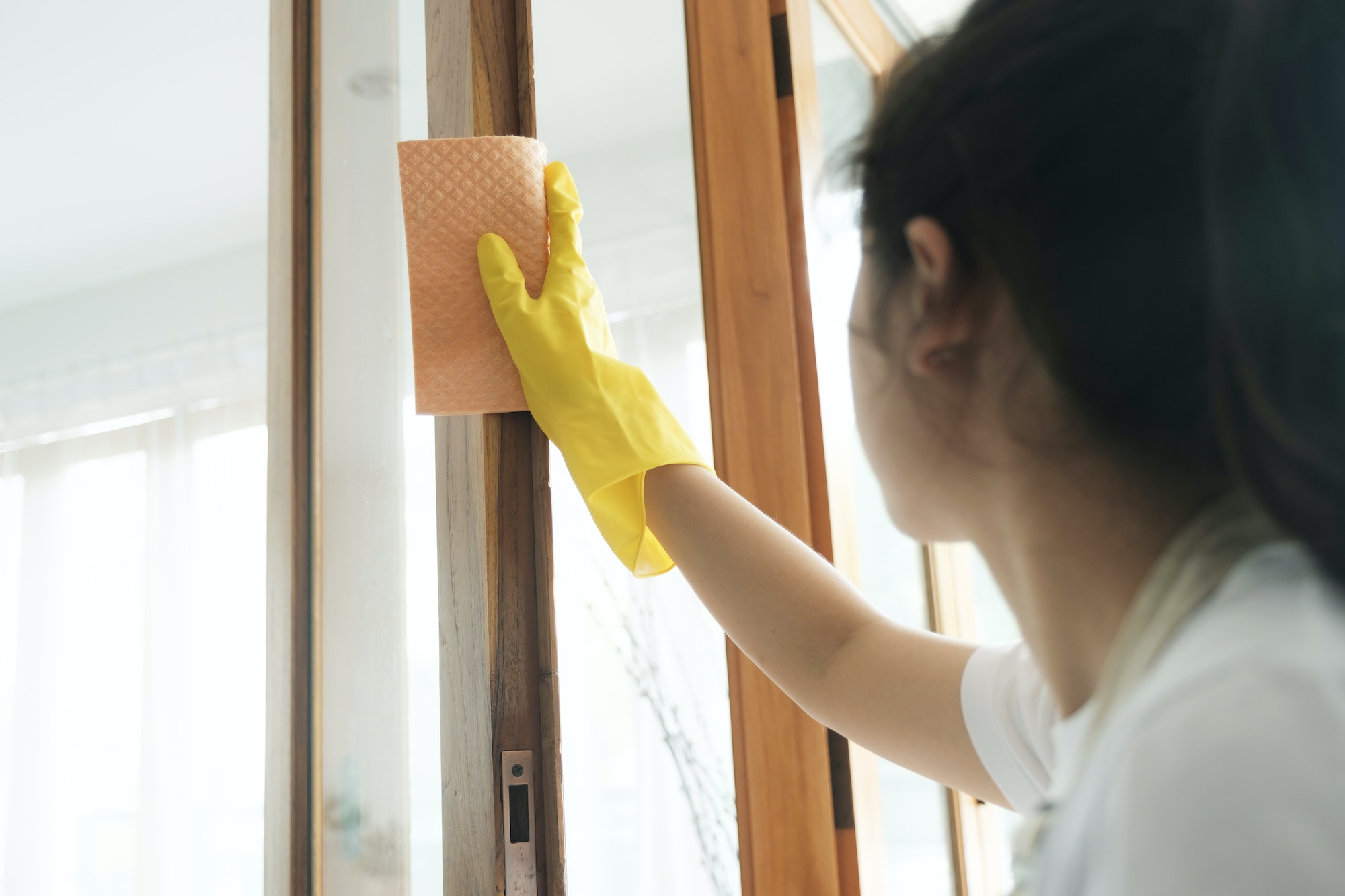 Young woman cleaning window.